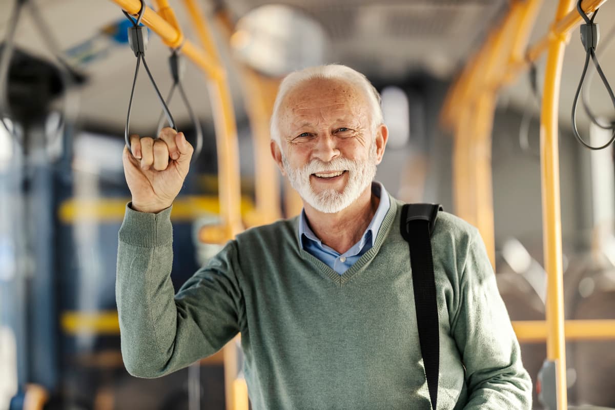 homem idoso feliz aposentado dentro de ônibus