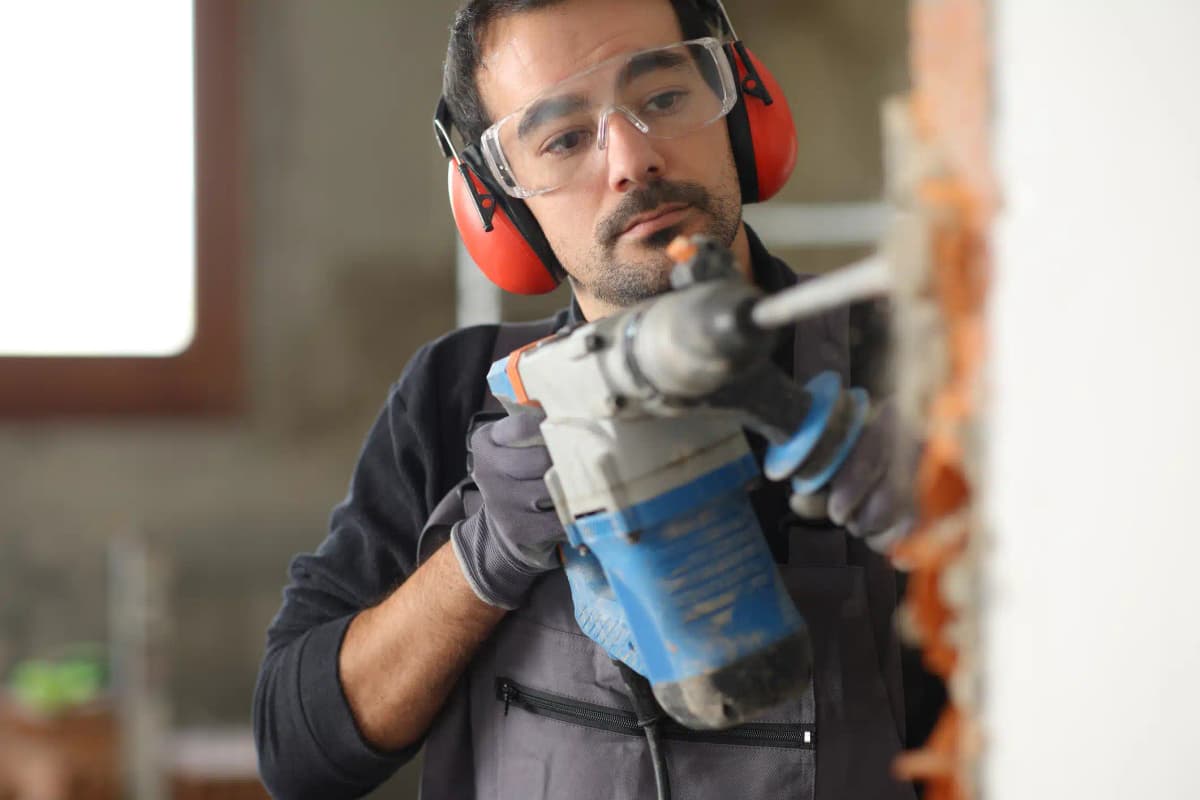 homem trabalhando com ruido usando protecao nos ouvidos